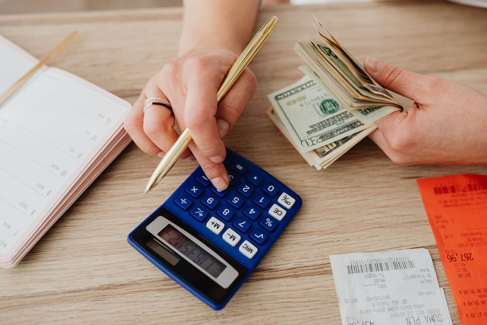 Calculating travel budget with calculator, cash, and receipts