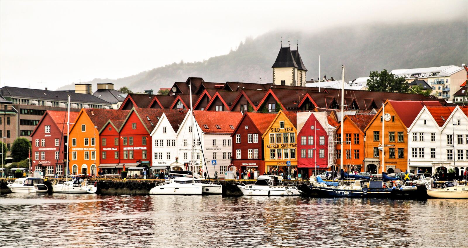 Colorful Bryggen wharf houses reflected in Bergen harbor