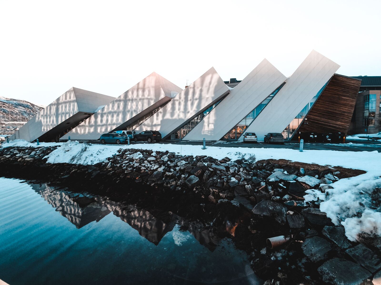 Modern white building reflected in water near Bodo, Norway